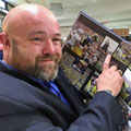 Superfan with University of Michigan football gift picture book WOLVERINE: A Photographic History of Michigan Football, Vol. 1